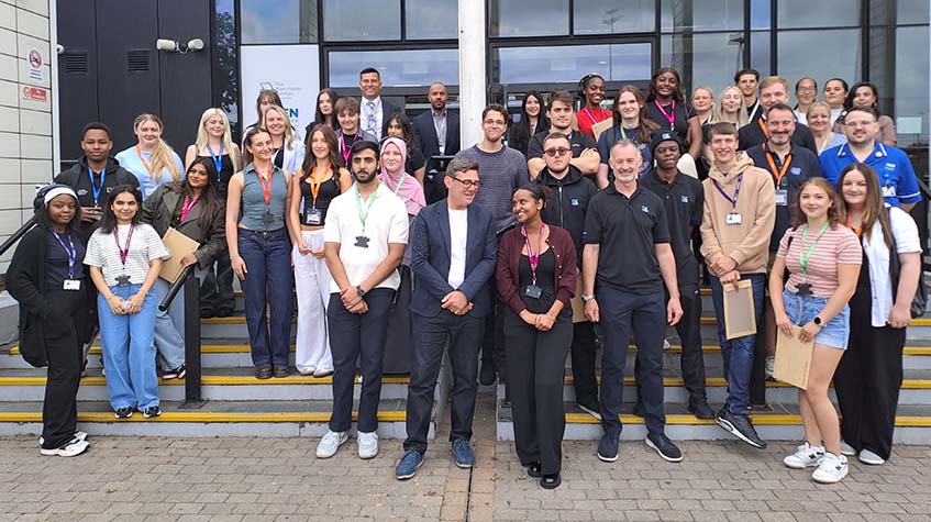 A group image of learners, staff and employers on the steps of The Manchester College's Openshaw campus. Greater Manchester Mayor, Andy Burnham is front and centre chatting to a student.