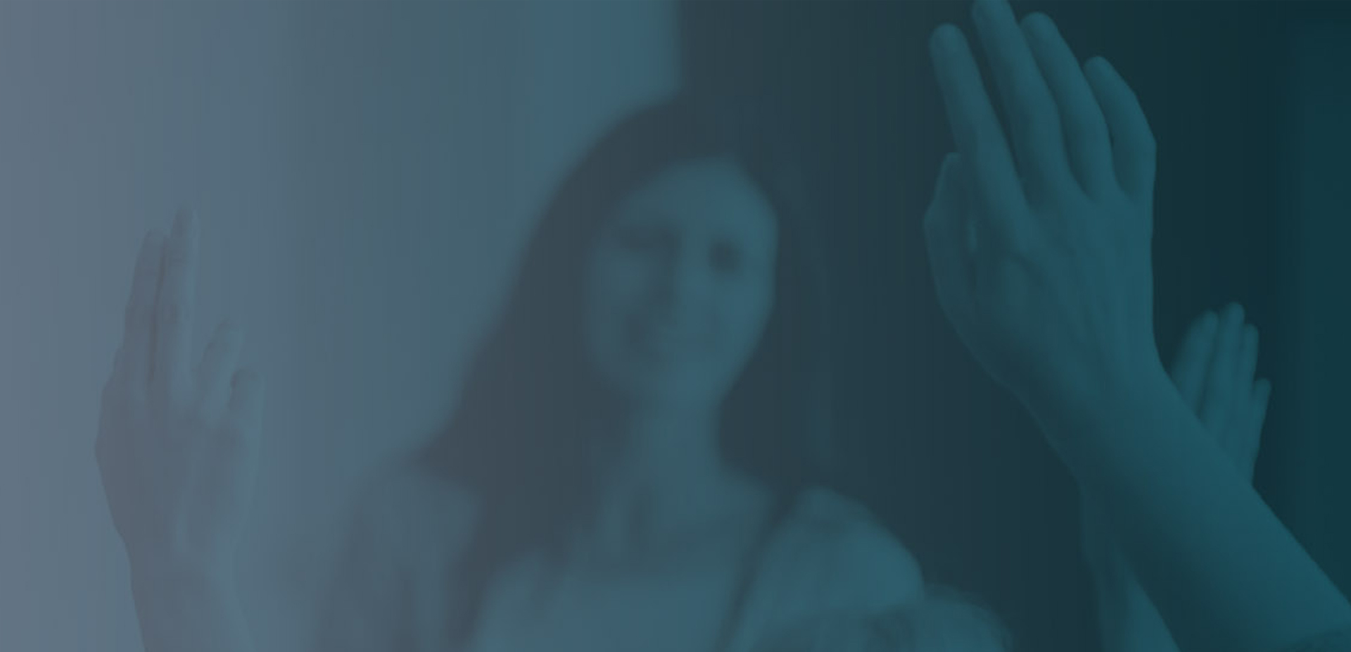 A teacher at the front of a class, with multiple hands raised