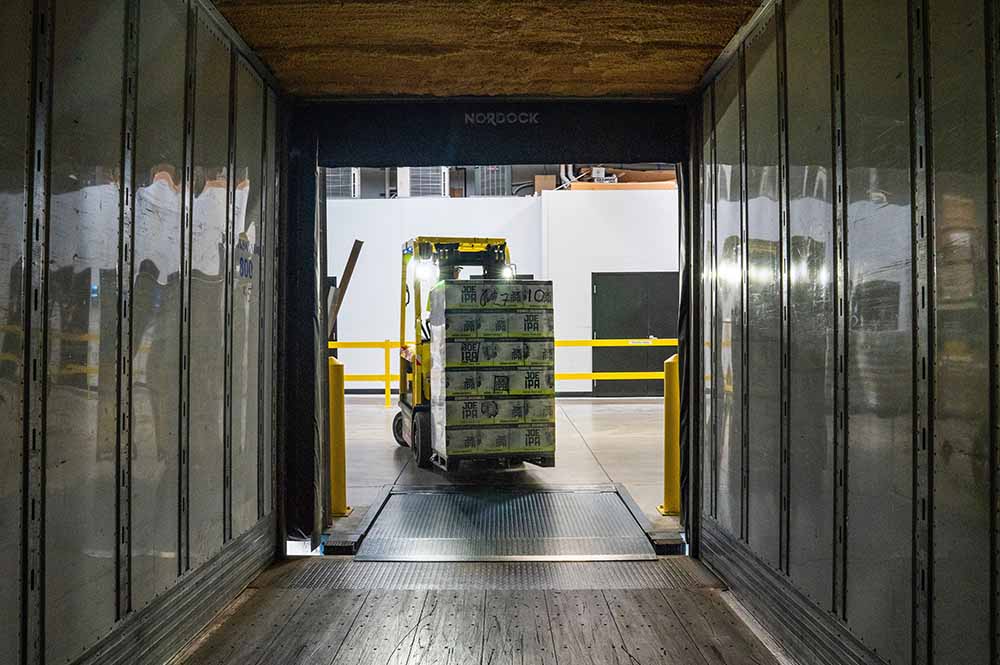 Yellow and black fork lift driving into a cargo hold