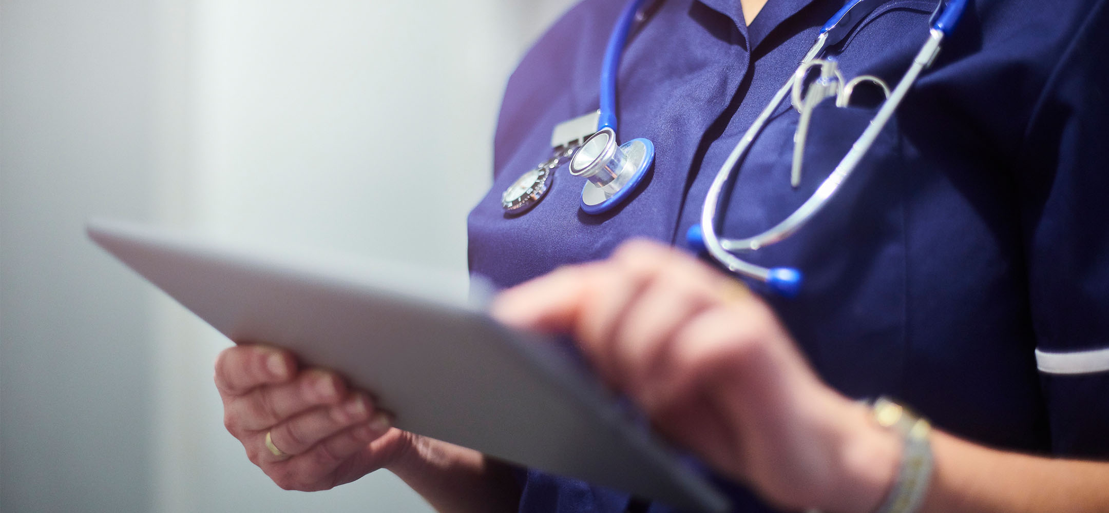 A healthcare professional writing on a clipboard