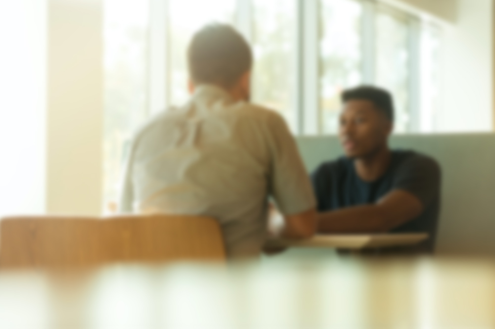 Two people talking to each other over a table