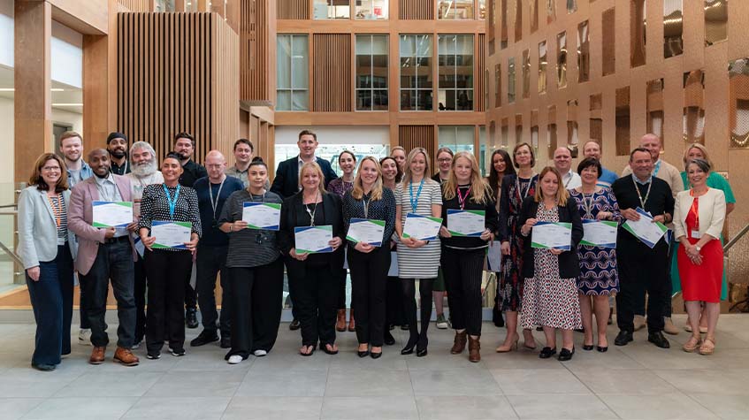 A group shot of The Manchester College colleagues holding their certificates having completed the Leadership of Learning programme.