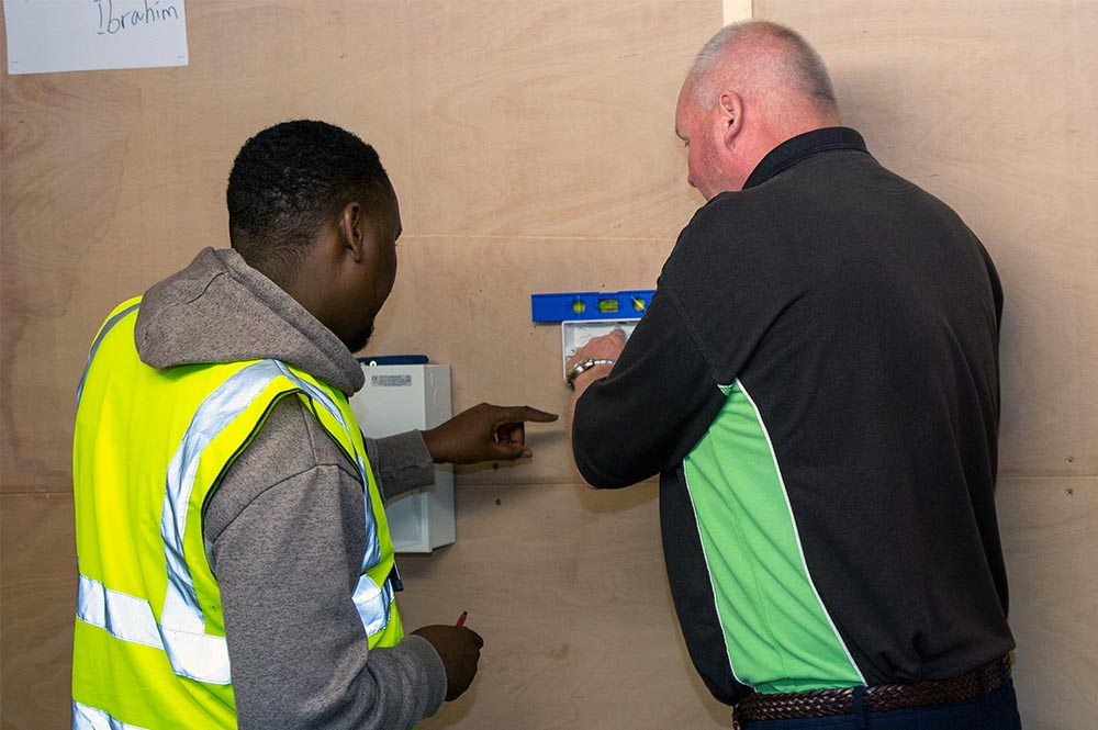 Electrical student and tutor working together