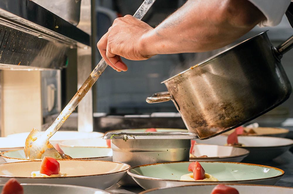 Food being ladelled into a dish