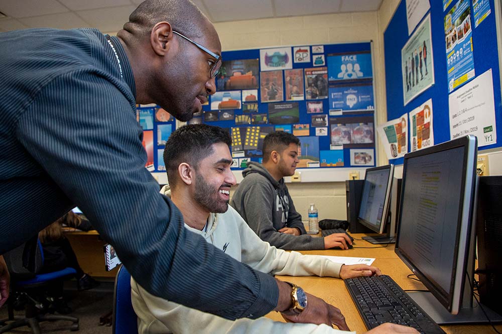 A tutor helping a student on a computer