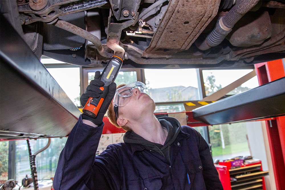 Mechanic looking underneath a car
