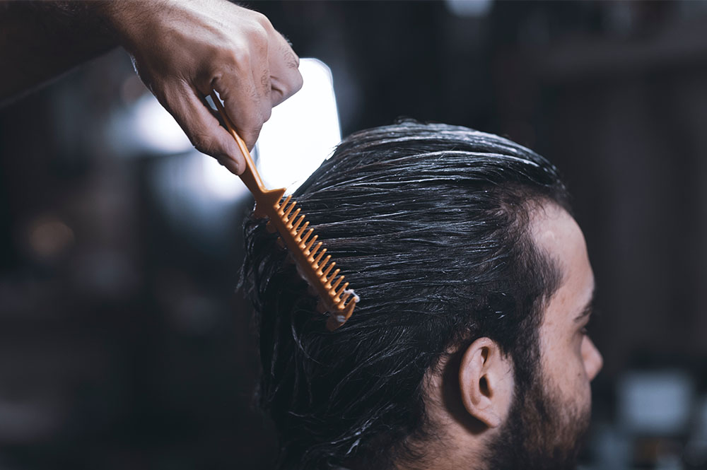 A mans hair being combed