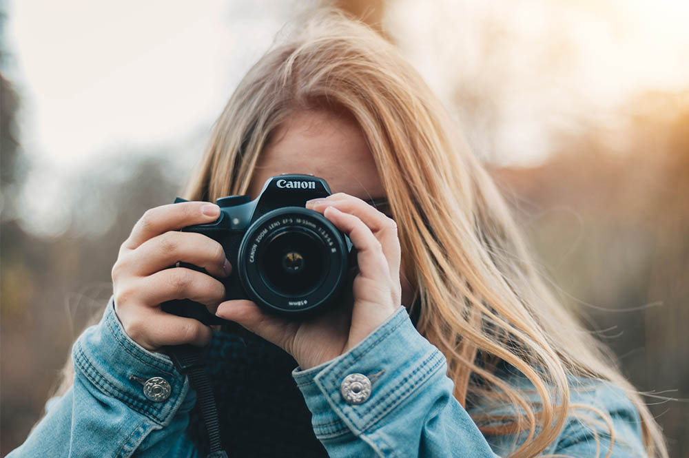 A student holding a canon DSLR