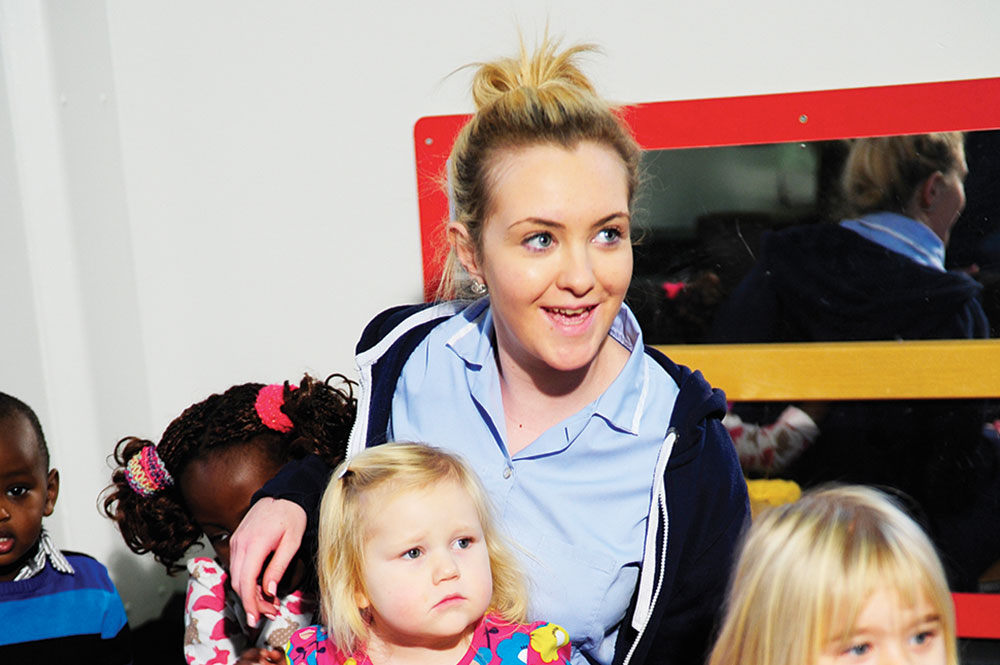 Image of a early years nursery practitioner looking after a group of children