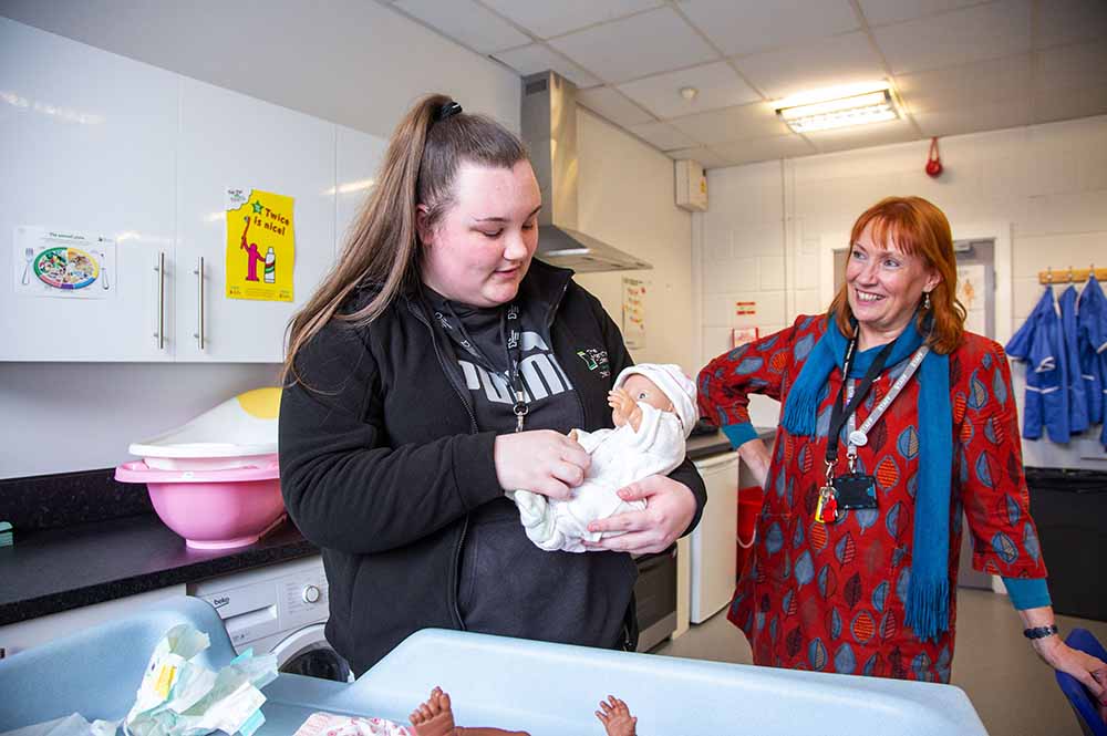 A student holding a model baby