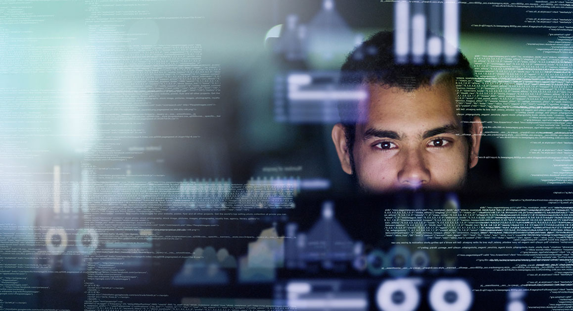 A man looking at a creen full of computer codes