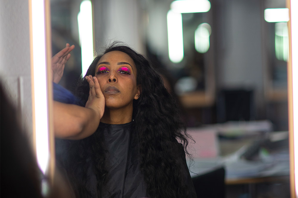 A student having theatrical make-up applied