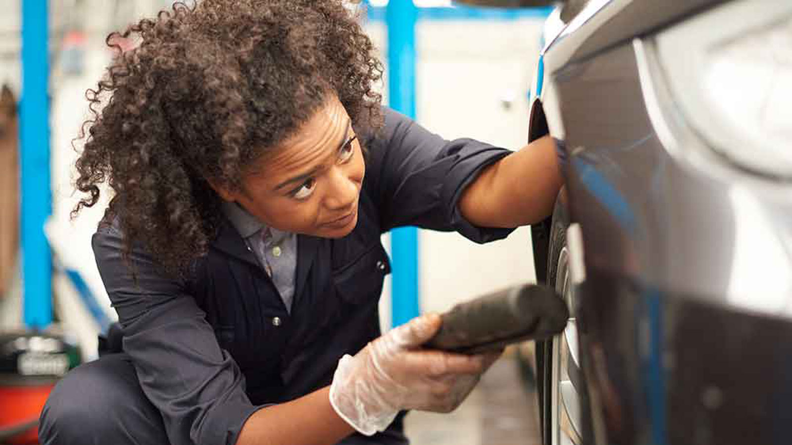 Female mechanic working on a car