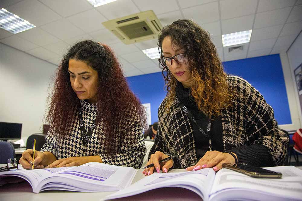 Two students reading a textbook