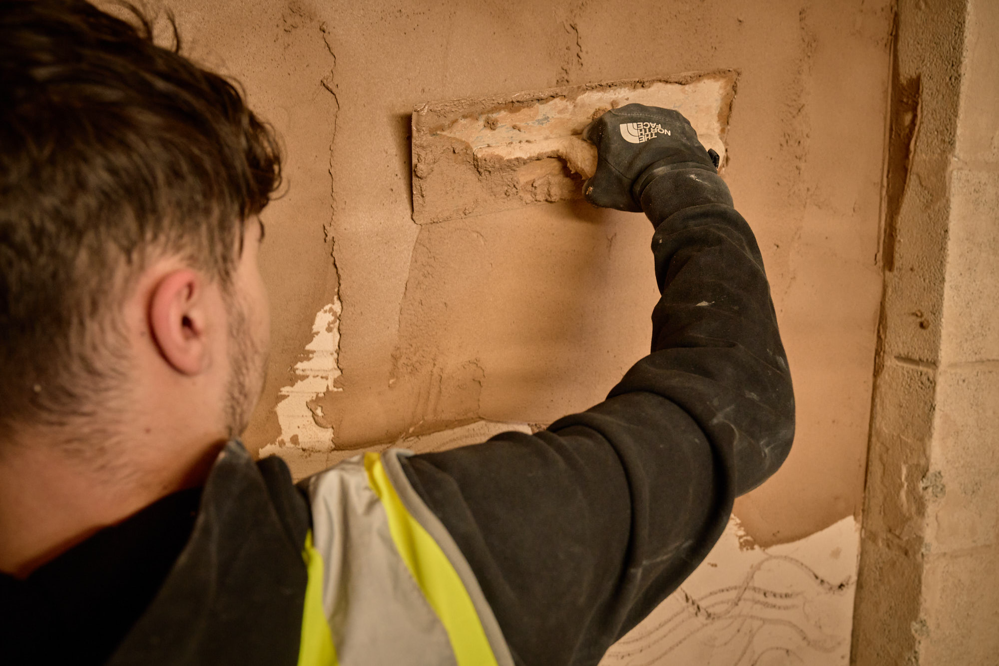 Close up of student plastering a wall