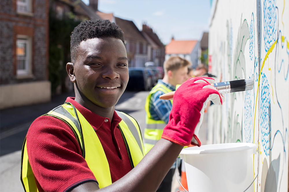 Close-up of a learner helping clean a wall
