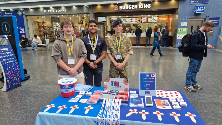 Students from The Manchester College at Manchester Piccadilly Station running a Royal British Legion Poppy Appeal donation stand.