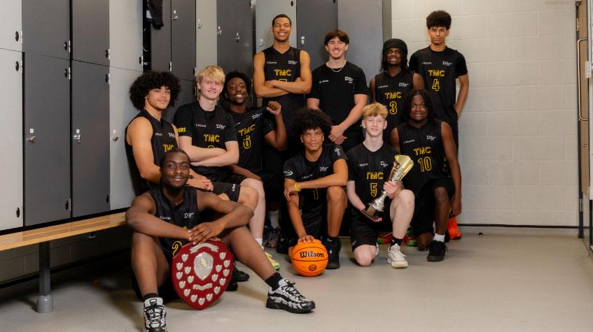 The Manchester College men's basketball team with the trophy after winning the 2026 North West League title.