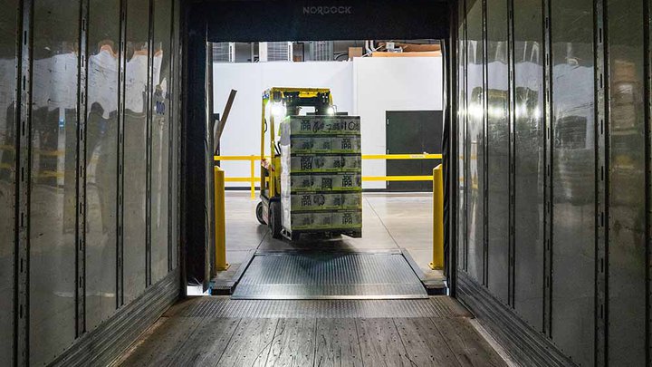 Yellow and black fork lift driving into a cargo hold