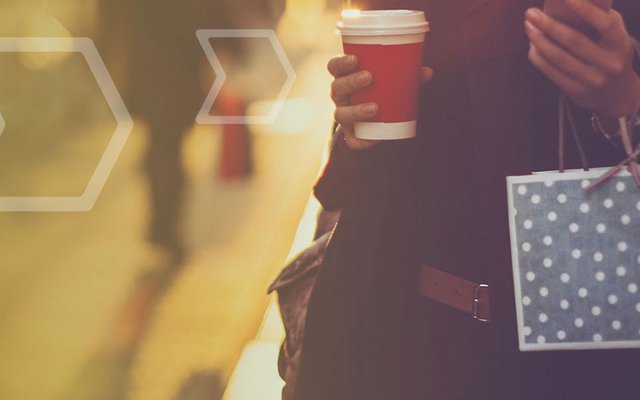 Woman holding coffee cup and a bag