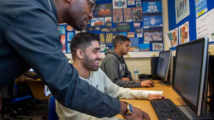 A tutor helping a student on a computer