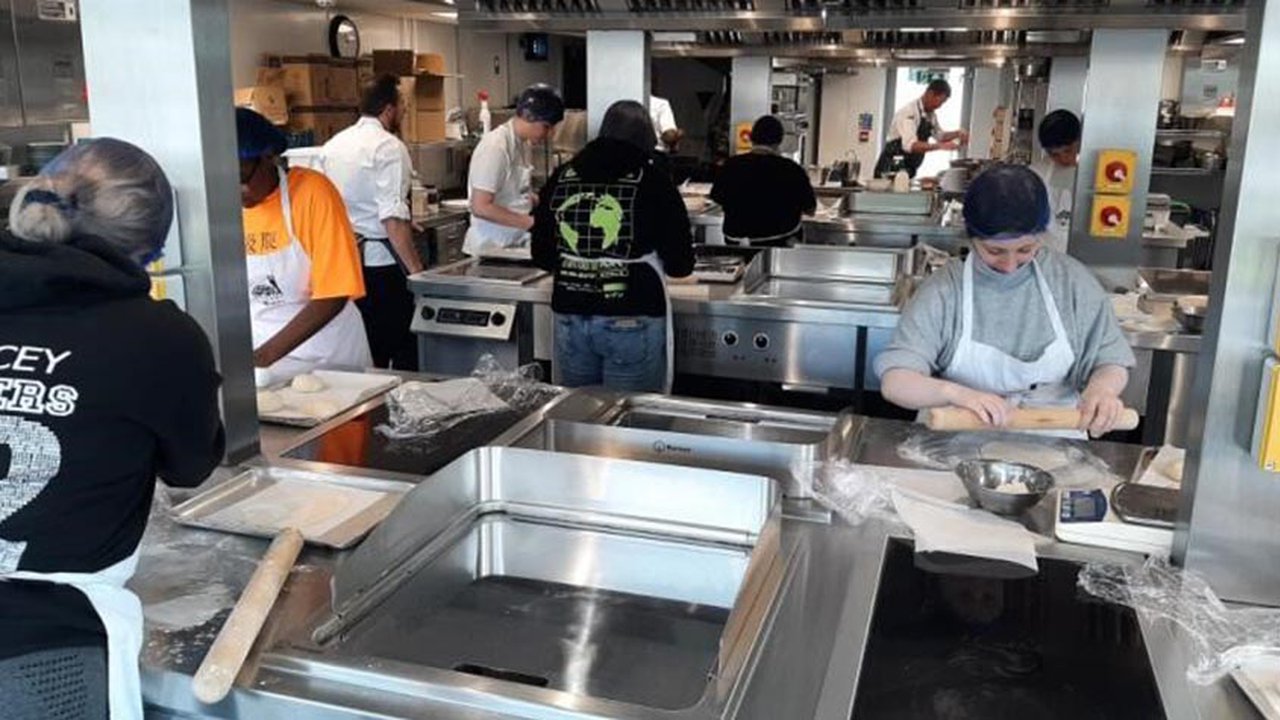 Photograph of prospective students in one of The Manchester College's training kitchens.
