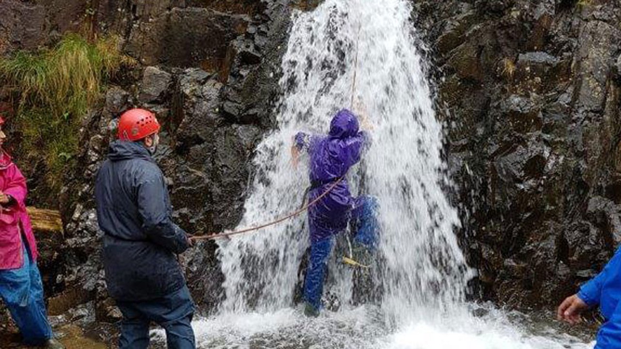 students tackle waterfall in team bonding exercise