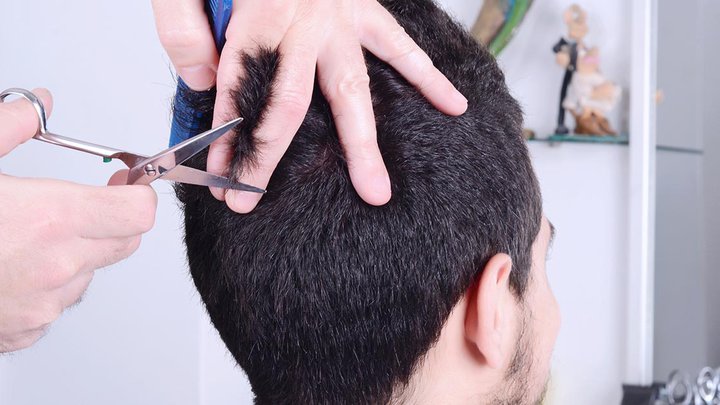 A mans hair being cut