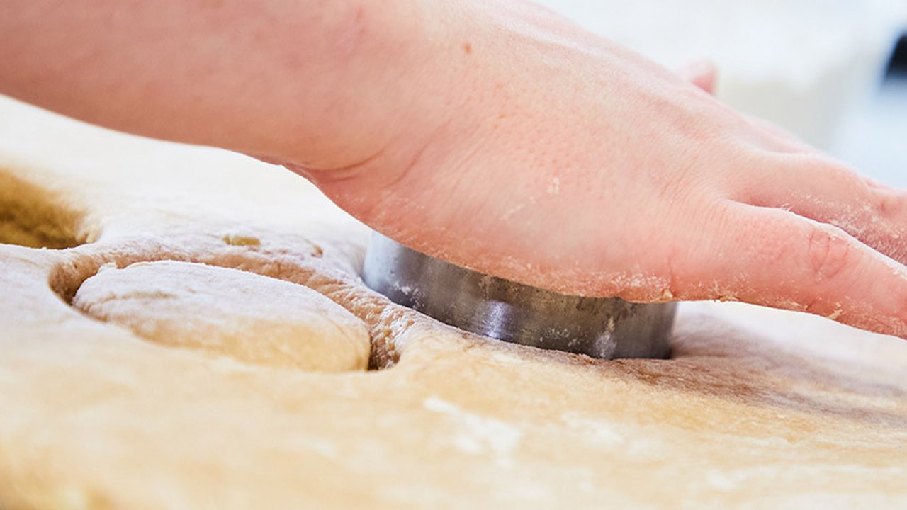 Photograph of an individual baking in a kitchen at one of The Manchester College's campuses.