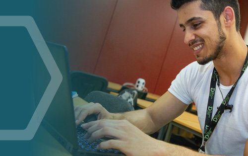 A male student typing on a computer in a classroom