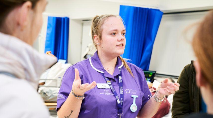 Health and social care student at The Manchester College talking to prospective students during an open event.
