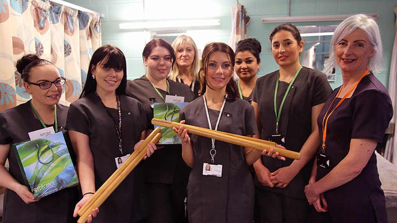 Students with bamboo massage therapy tools