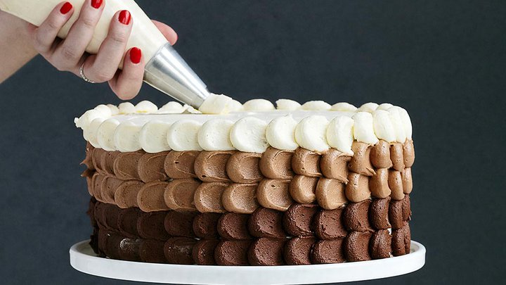 A cake being decorated with multiple layers