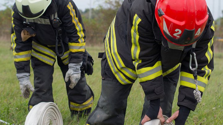 Two firefighters rolling out a hose