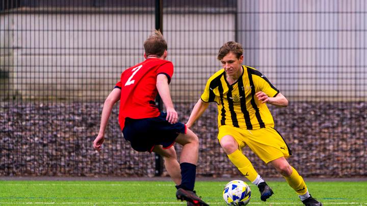 Two males playing football