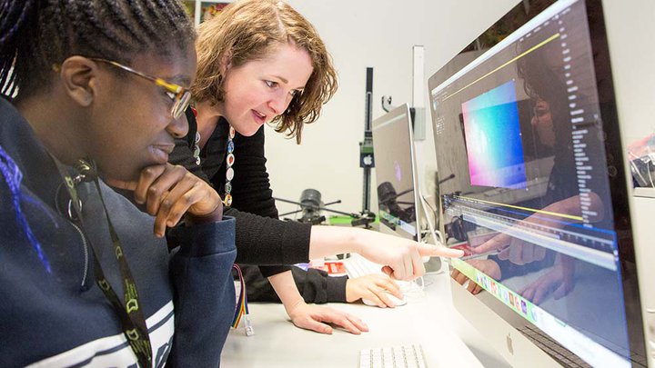 A tutor and student looking at a MacBook screen