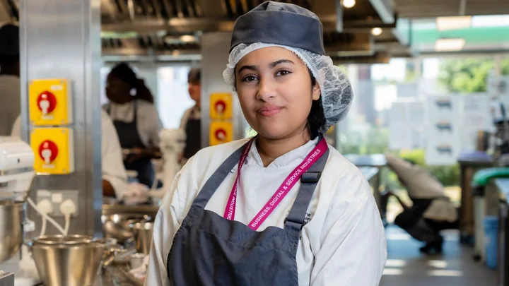 Catering student wearing kitchen uniform in a professional food preparation environment