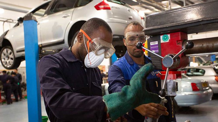 Two college students operating a piece of machinery