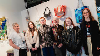 Art students and staff pose at exhibition