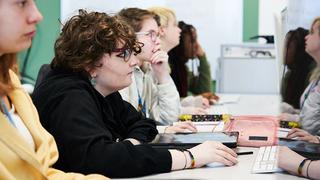 Photograph of Lily Curbishley and fellow students in a classroom setting.