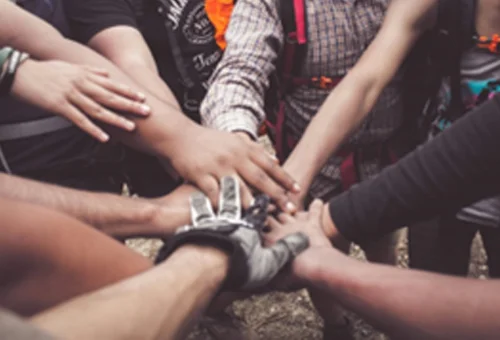 Close-up of people stacking their hands as a sign of bonding