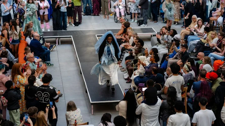 Student model showcasing a fashion design on a runway during a Visual Arts fashion show at The Manchester College.