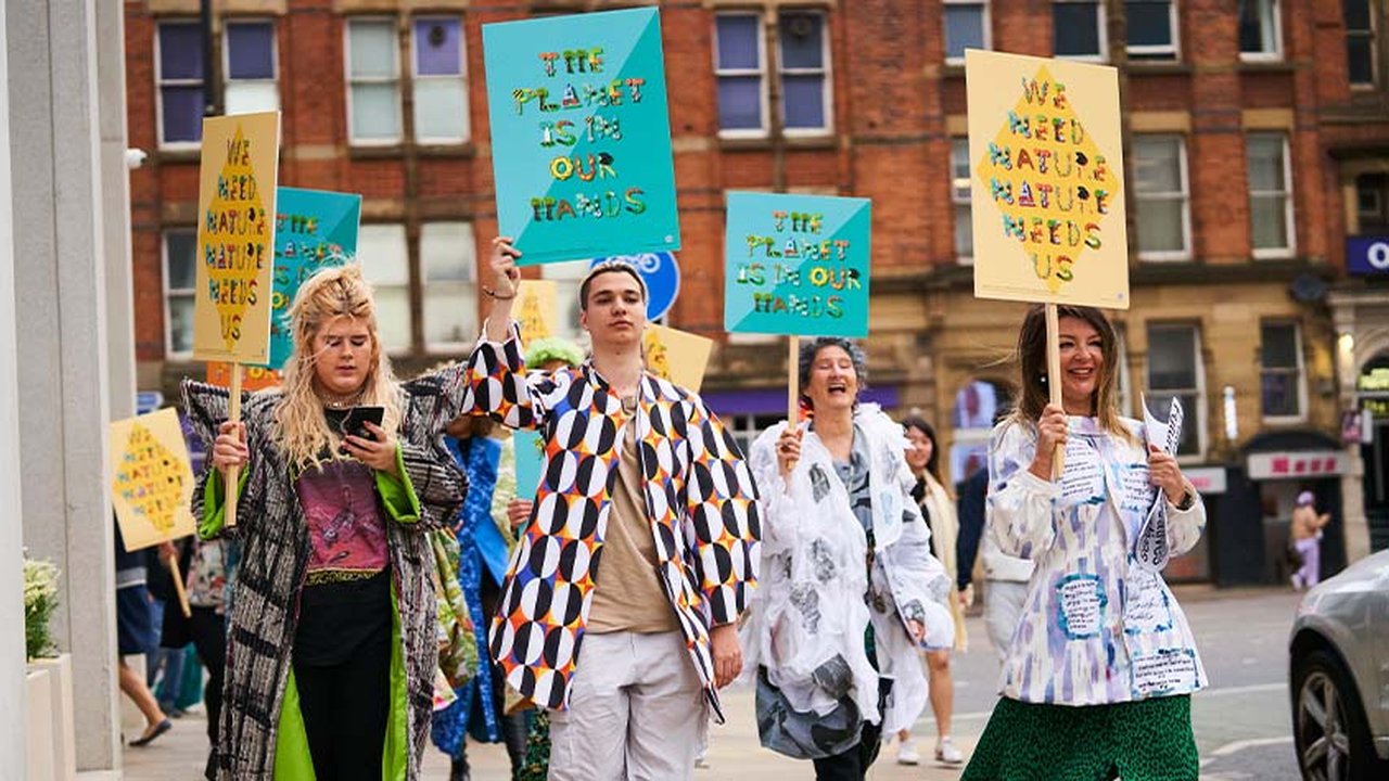 A group of people walk through Manchester City Centre with placards calling for better protection for nature and the environment.