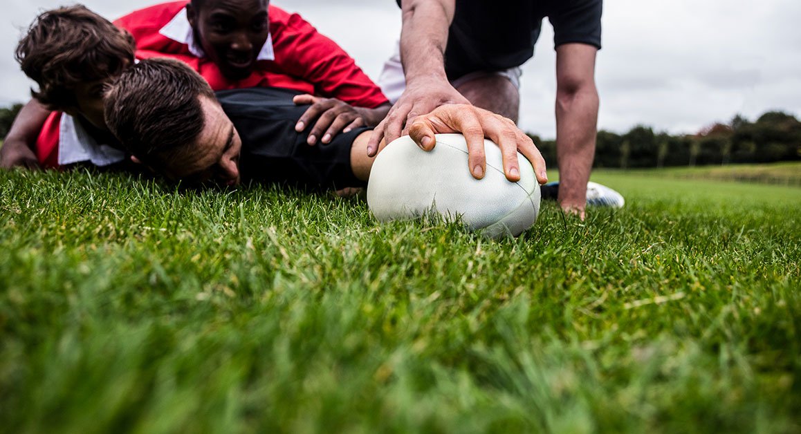 Four men playing rugby