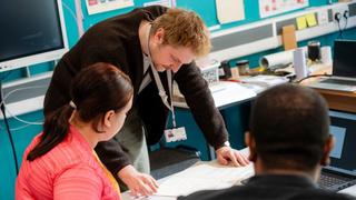 The Manchester College tutor supporting learners during a classroom-based practical activity.