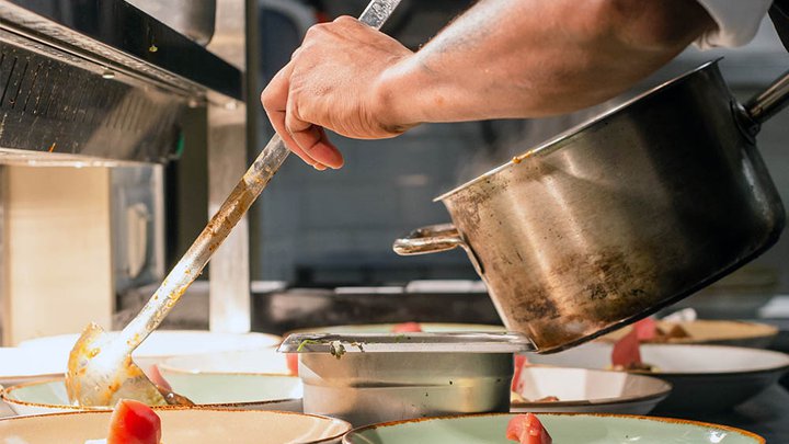 Food being ladelled into a dish