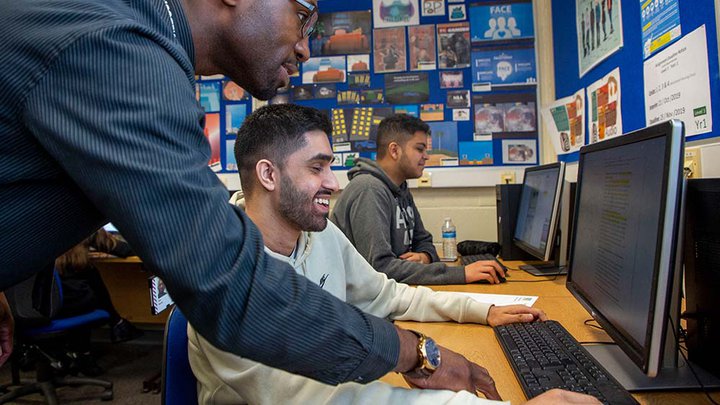 A tutor helping a student on a computer