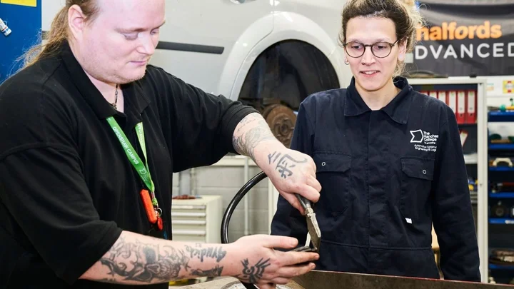 Automotive learners working together on a hands‑on practical task using specialist tools during an Automotive training session.