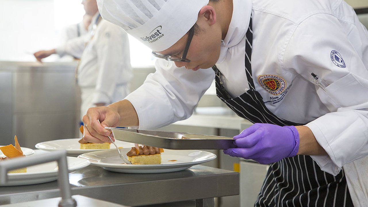 A young chef prepares a dish in the finals