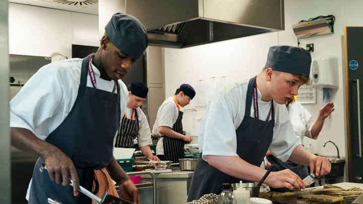 Hospitality and Catering students preparing and cooking food in a professional training kitchen at The Manchester College.